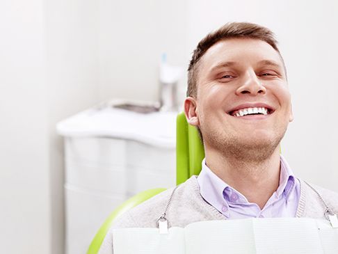Smiling dental patient in a chair