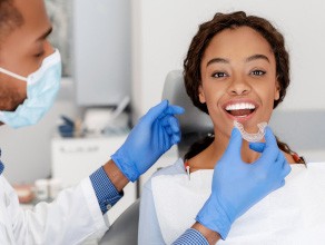 A dentist placing ClearCorrect aligners on a woman’s teeth