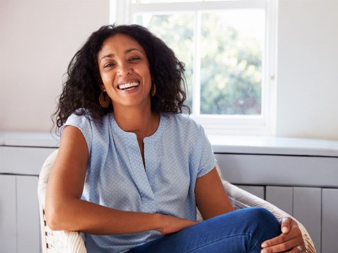 Woman smiling while sitting on chair at home