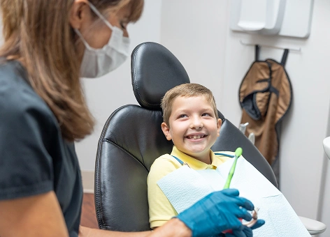 Smiling child in a dental chair with a dentist